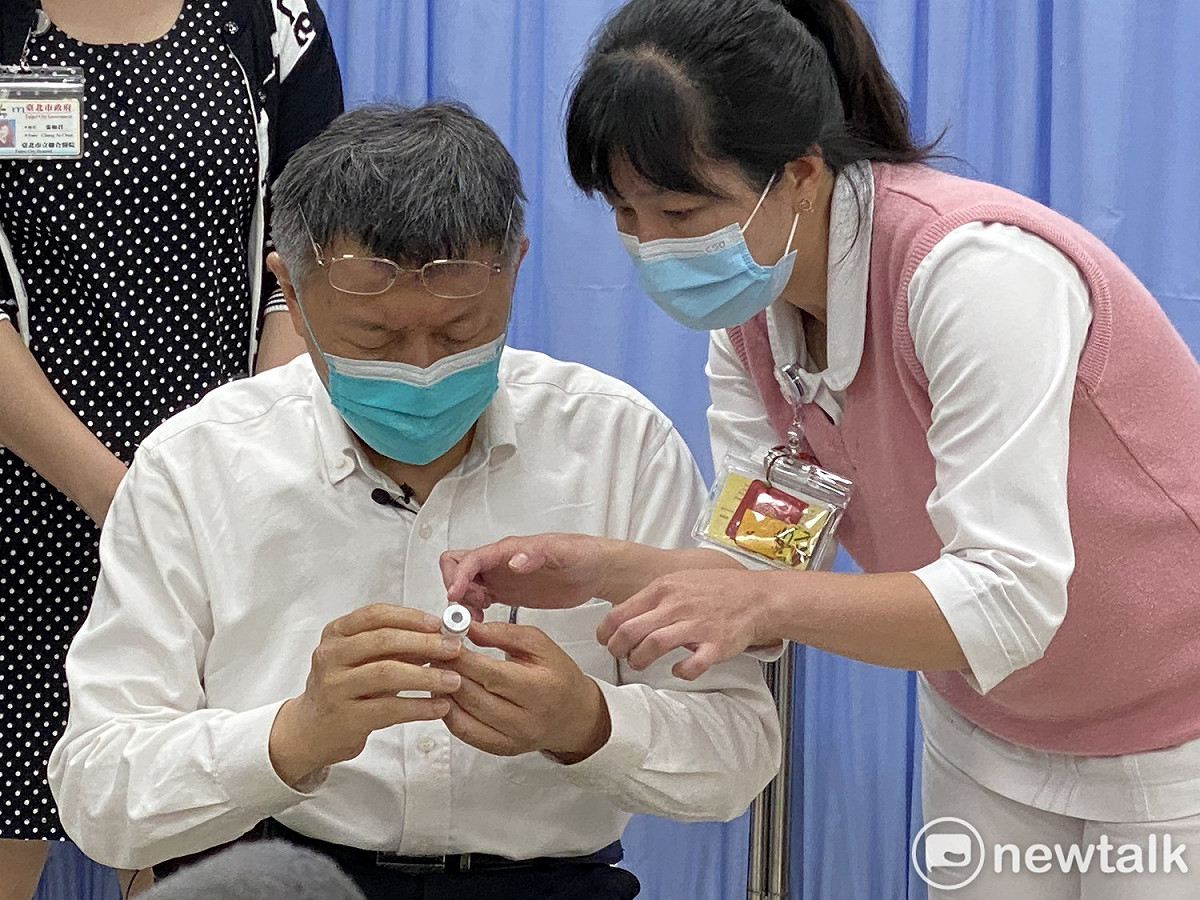 台北市長柯文哲施打AZ疫苗前，先查看一下要施打的疫苗。 圖：周煊惠 / 攝