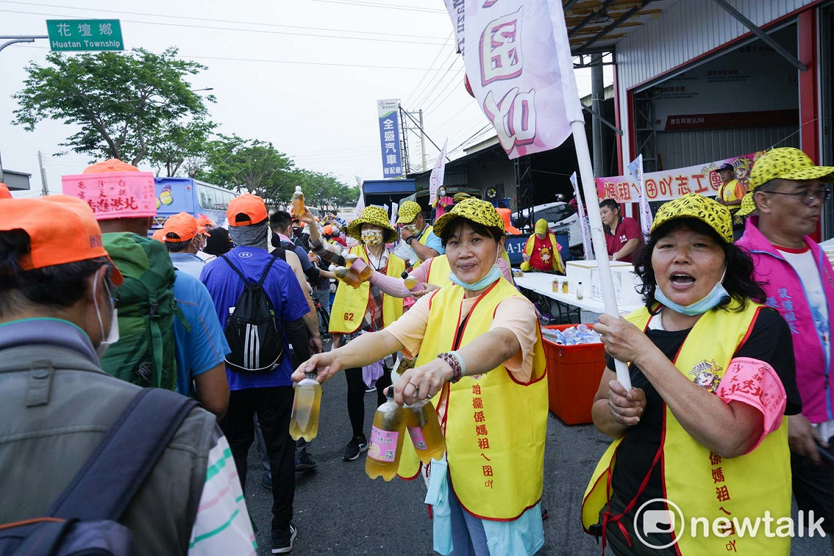白沙屯媽祖的信眾在彰化花壇中山路上遞水給香燈腳們。 圖：張良一/攝