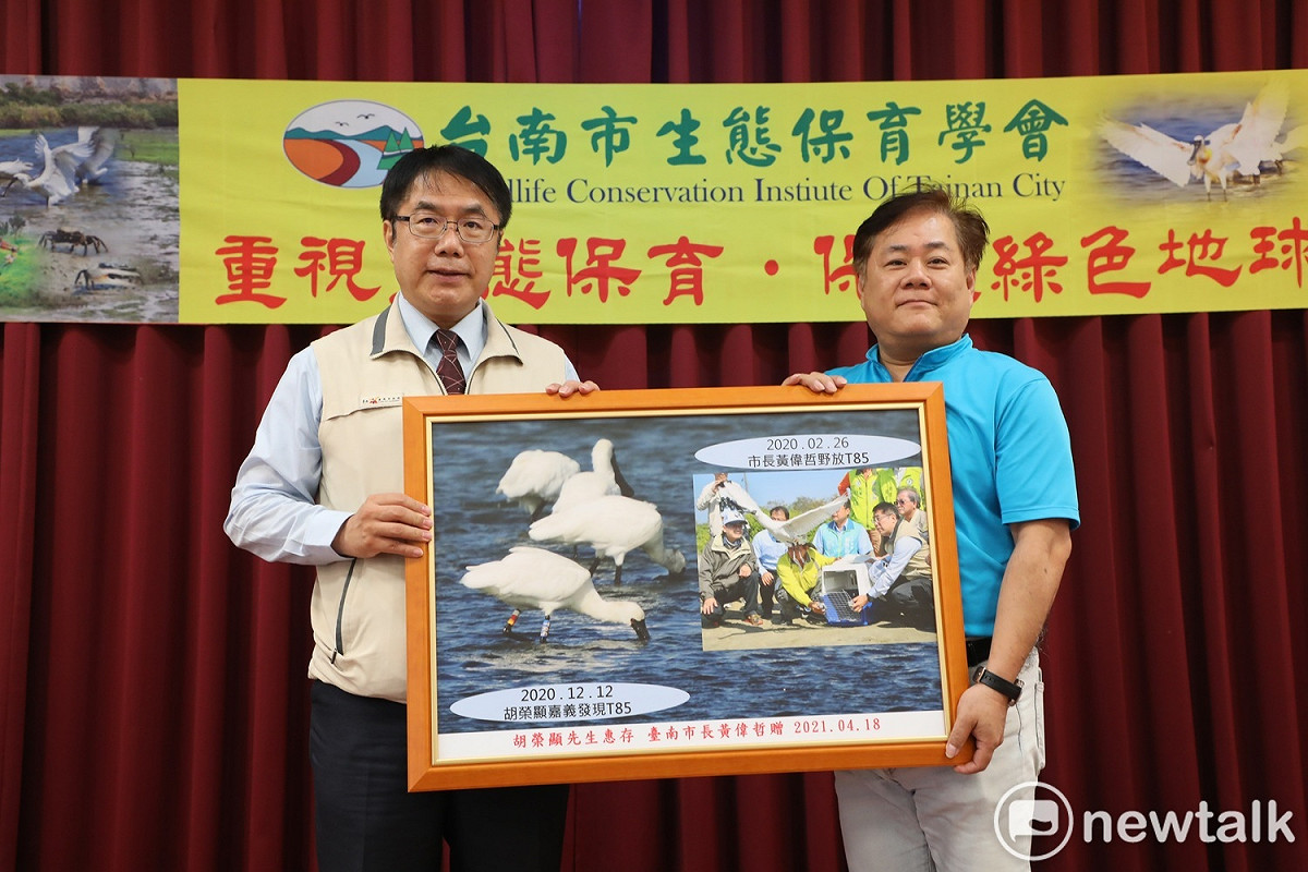 台南市長黃偉哲(左)親自頒發匾額及精美紀念品給第一位發現T85黑琵鳥友胡榮顯，感謝他對生態的關心。 圖：台南市政府提供