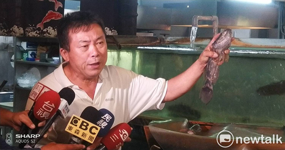 賴秋基抓起一隻筍殼魚嘆，缺水期的魚又小又貴又缺貨。 圖：孫家銘/攝