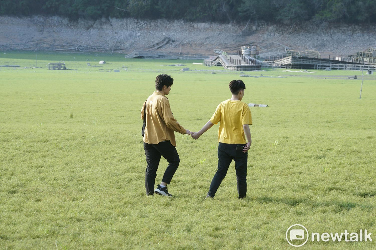一對戀人手牽著手走在日月潭乾涸的湖底。 圖：張良一/攝
