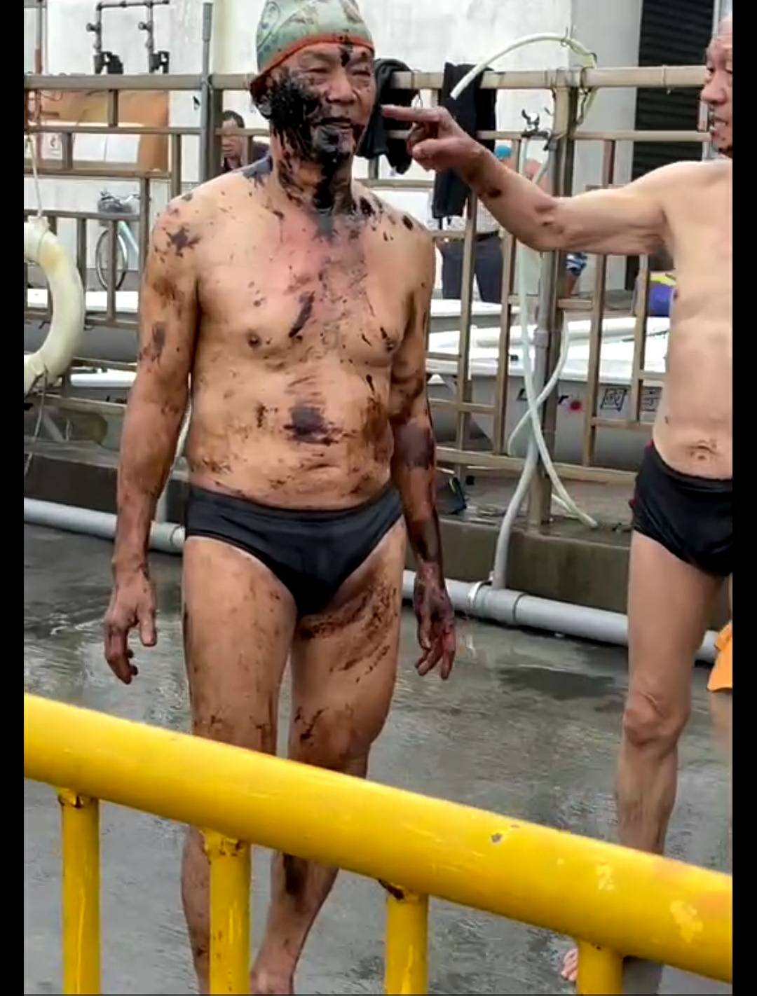 泳客在高雄市西子灣晨泳後上岸，全身沾滿油汙。 圖：民眾提供