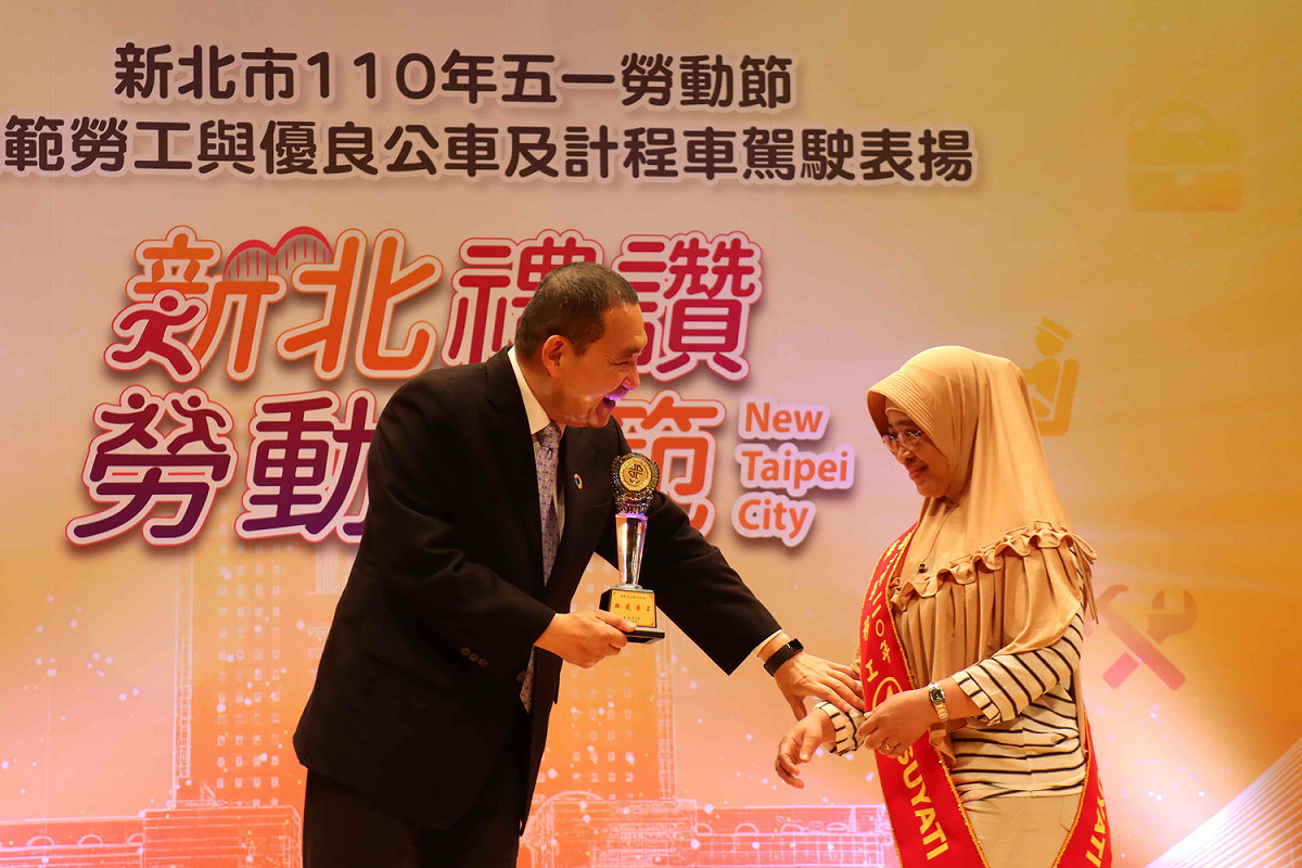 侯友宜牽起印尼模範移工亞蒂的手，予以頒獎表揚。 圖：新北市勞工局提供