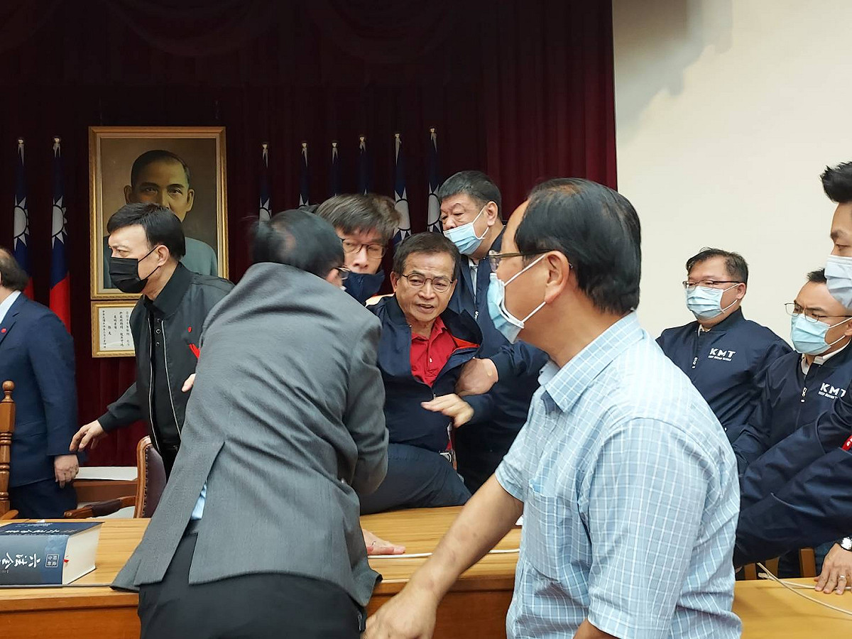 立委賴士葆（中穿紅衣者）衝上主席台，被多名委員架著離開。 圖：陳佩君/攝