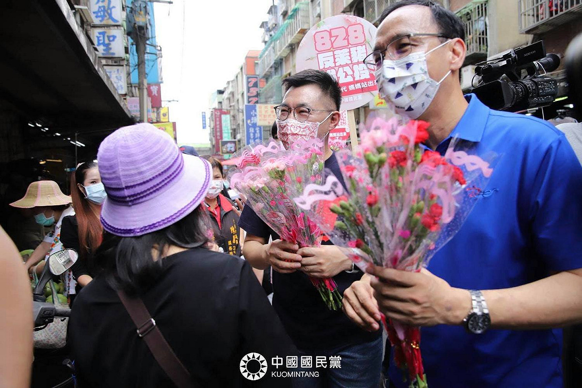江啟臣（左）與朱立倫（右）合體，在市場內發康乃馨，並宣傳828反萊豬公投。 圖：翻攝自國民黨臉書