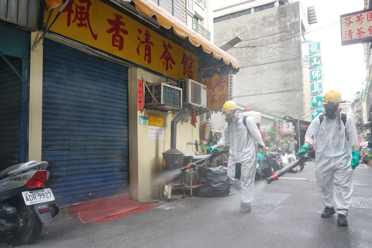 傳出確診案例的楓香清茶館已拉下鐵門暫停營業，而市府衛生局也派員在店外消毒。 圖：張良一/攝