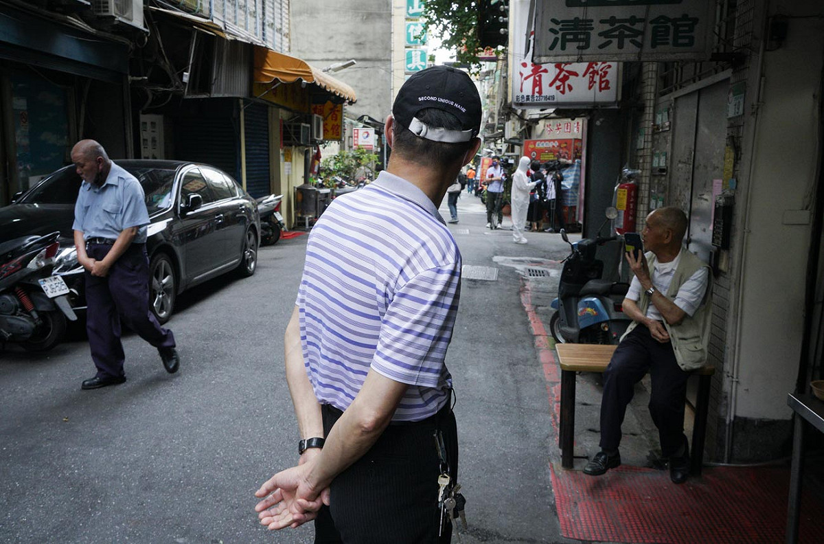 北市萬華區西園路的楓香清茶館傳出武漢肺炎案例後，吸引大批媒體記者到場採訪。圖為一些民眾站在清茶館外看媒體記者採訪。 圖：張良一/攝