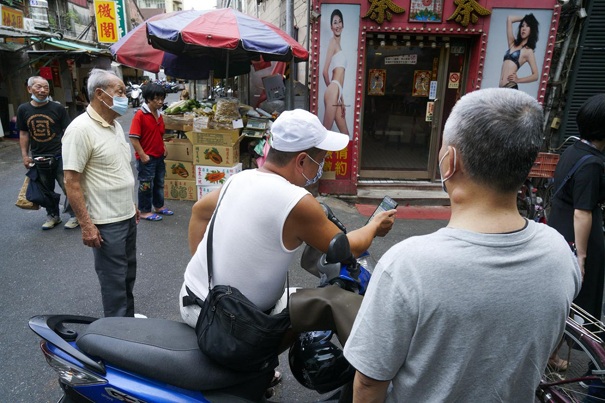北市萬華區三水街的鴻達清茶館傳出武漢肺炎案例後，吸引大批媒體記者到場採訪。圖為一些民眾站在清茶館外看媒體記者採訪。 圖：張良一/攝