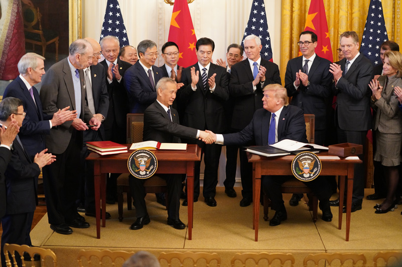 中國貿易談判代表劉鶴（坐者左起）與美國前總統川普，在2020年1月簽訂第一階段貿易協議。 圖：翻攝自中國政府網