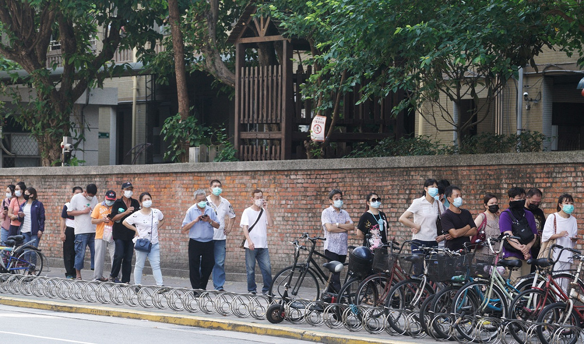 排隊人潮擠爆剝皮寮外走道，還滿到老松國小圍牆外。 圖：張良一/攝
