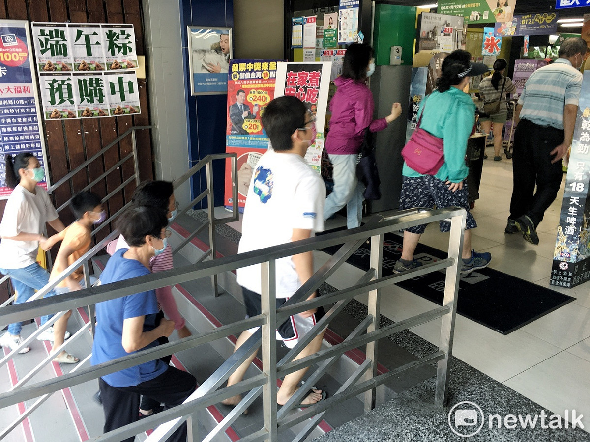 今行攻院公布，雙北5/15～5/28防疫升至第三級警戒，人潮一波波湧進超市搶購各項民生物資。 圖：張良一/攝