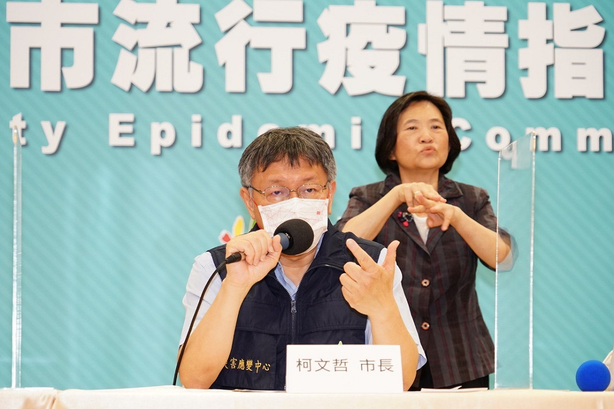 市長柯文哲今（15）日下午2時30分召開線上臨時記者會，記者會中站在後方、賣力將各項措施翻譯成手語的專業手譯員，卻意外成為不少話題的焦點。 圖 : 台北市政府 / 提供