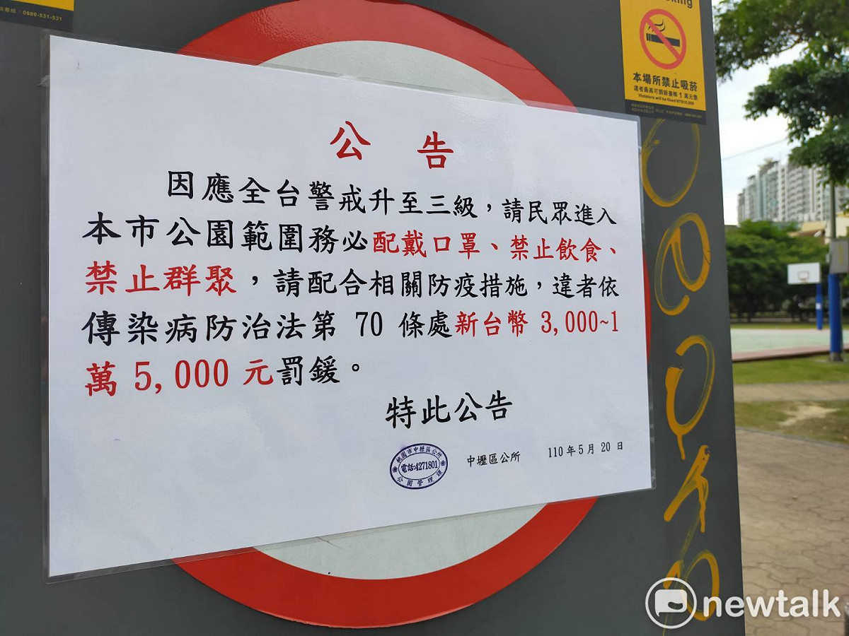公園入口張貼公告，提醒民眾需配合三級警戒規定，若經稽查違反者，可處3千至1.5萬元罰鍰。 圖：林昀真/攝