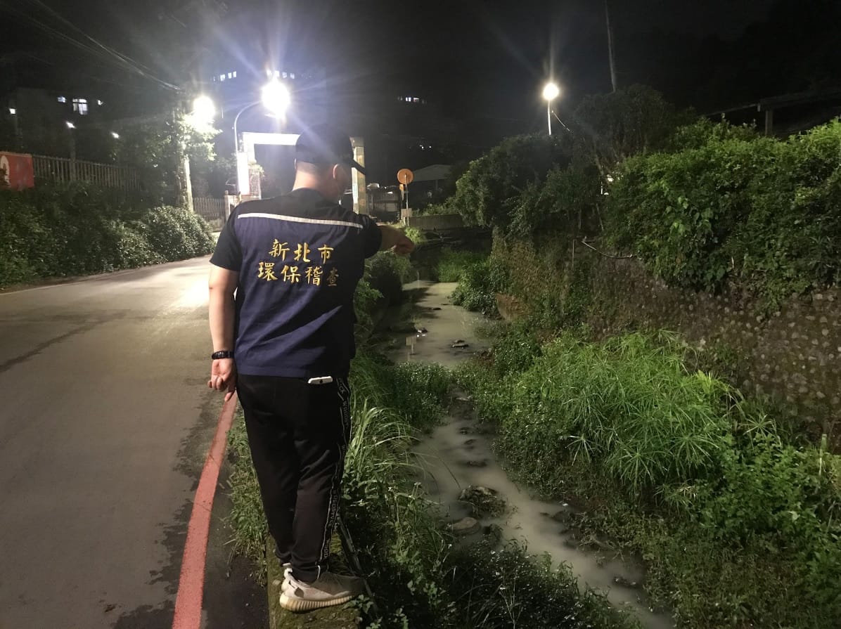 稽查員發現土城區石門路附近側溝遭不明廢水排入導致水色呈白色 圖：新北市環保局提供