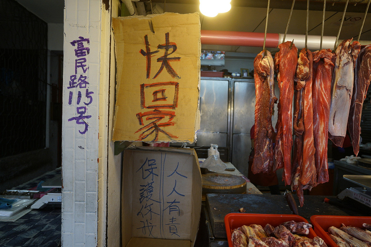 一家豬肉攤甚至掛起「快回家」紙板，希望顧客買完就走，不要再「開講」了！ 圖：張良一/攝