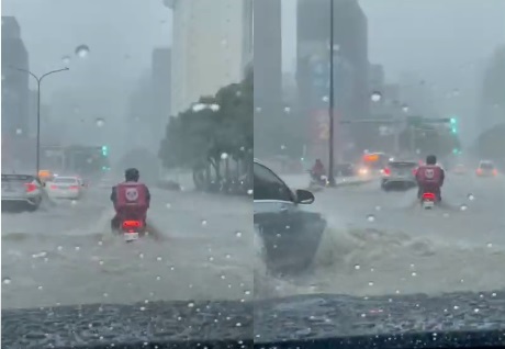 外送員頂著大雷雨以及道路淹水，騎在滾滾黃流中，畫面險象環生。 圖:翻攝畫面