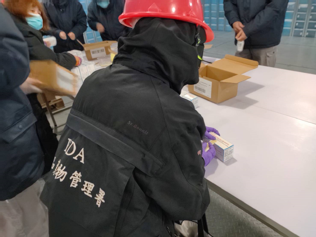 莫德納疫苗封緘作業中，黏貼藥物檢查證。 圖：食藥署／提供