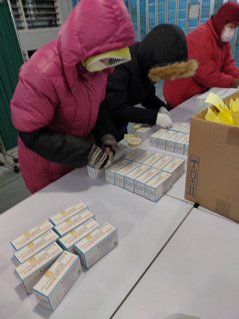 莫德納疫苗封緘作業中，黏貼藥物檢查證。 圖：食藥署／提供