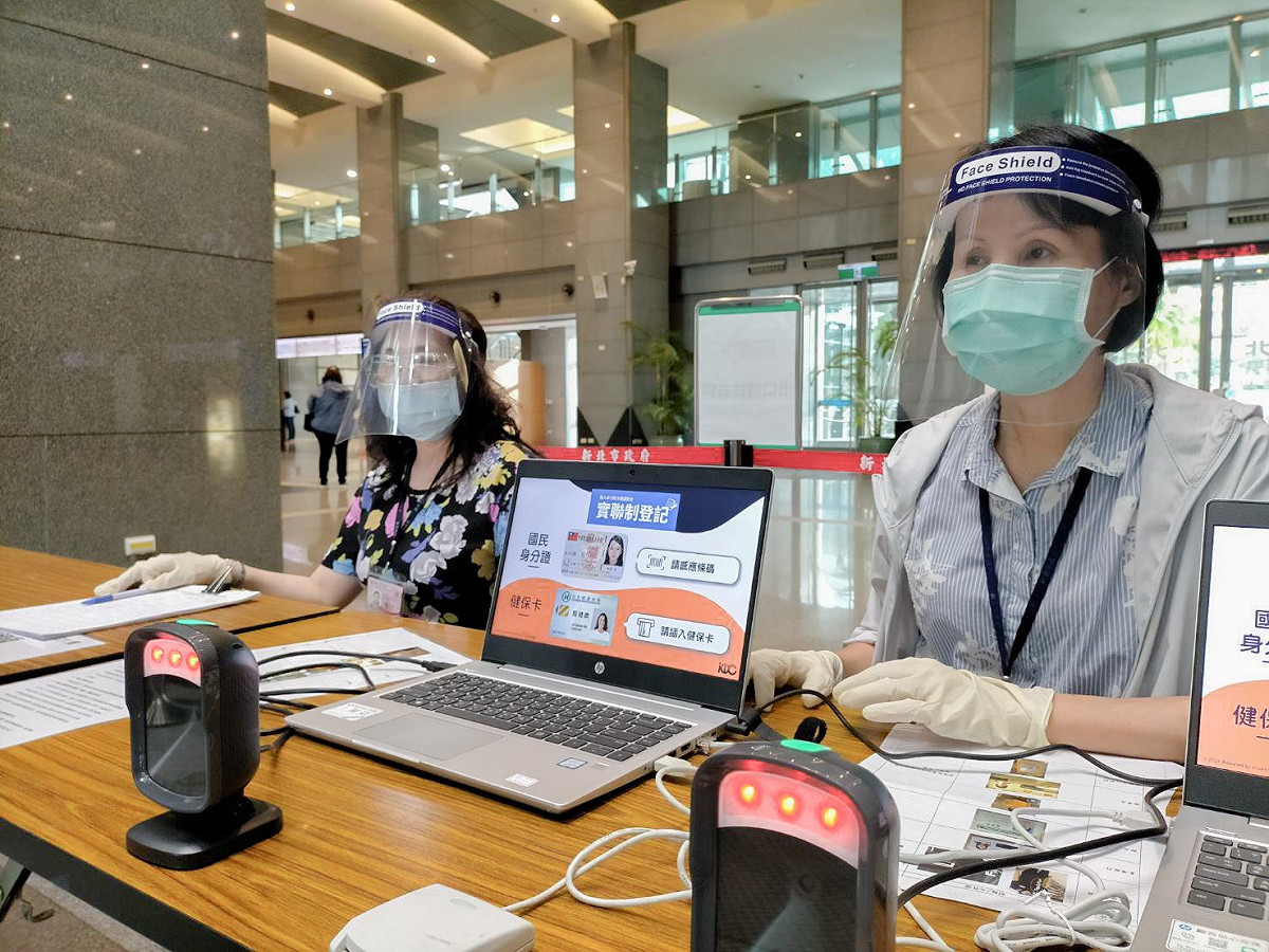 疫情持續嚴峻，一線人員配戴防護面罩服務民眾。 圖：新北市政府地政局/提供