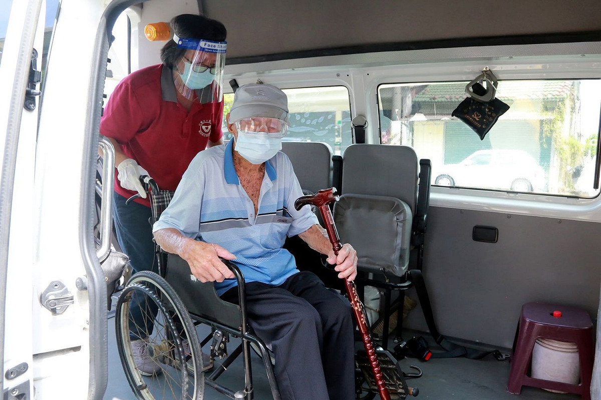 七股區樹林里101歲人瑞黃金從由市府安排復康巴士至家中接送至七股衛生所，經報到量體溫、酒精消毒、掛號及衛生所主任陳繼進醫師評估後，順利完成施打疫苗。 圖：台南市政府提供