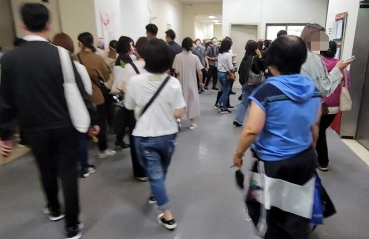 台中新光三越遭投訴，幾百人擠在一處不到2米寛的出口等打卡，明顯違反防疫規定。 圖：林祈烽提供