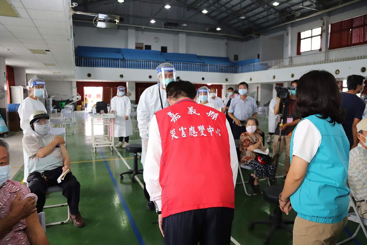 嘉義縣18日起實施第二波80至84歲長者疫苗施打，無縫接軌，縣長翁章梁（著紅背心者）向醫護人員鞠躬致意。 圖：嘉義縣政府/提供