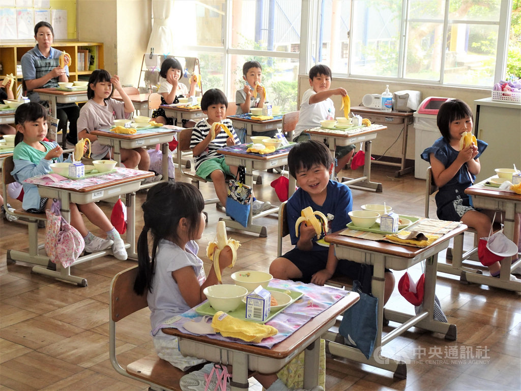 駐日代表謝長廷18日中午造訪東京奧運台灣隊接待城茨城縣笠間市，贈香蕉給當地學童，學童們吃得津津有味。 圖/中央社