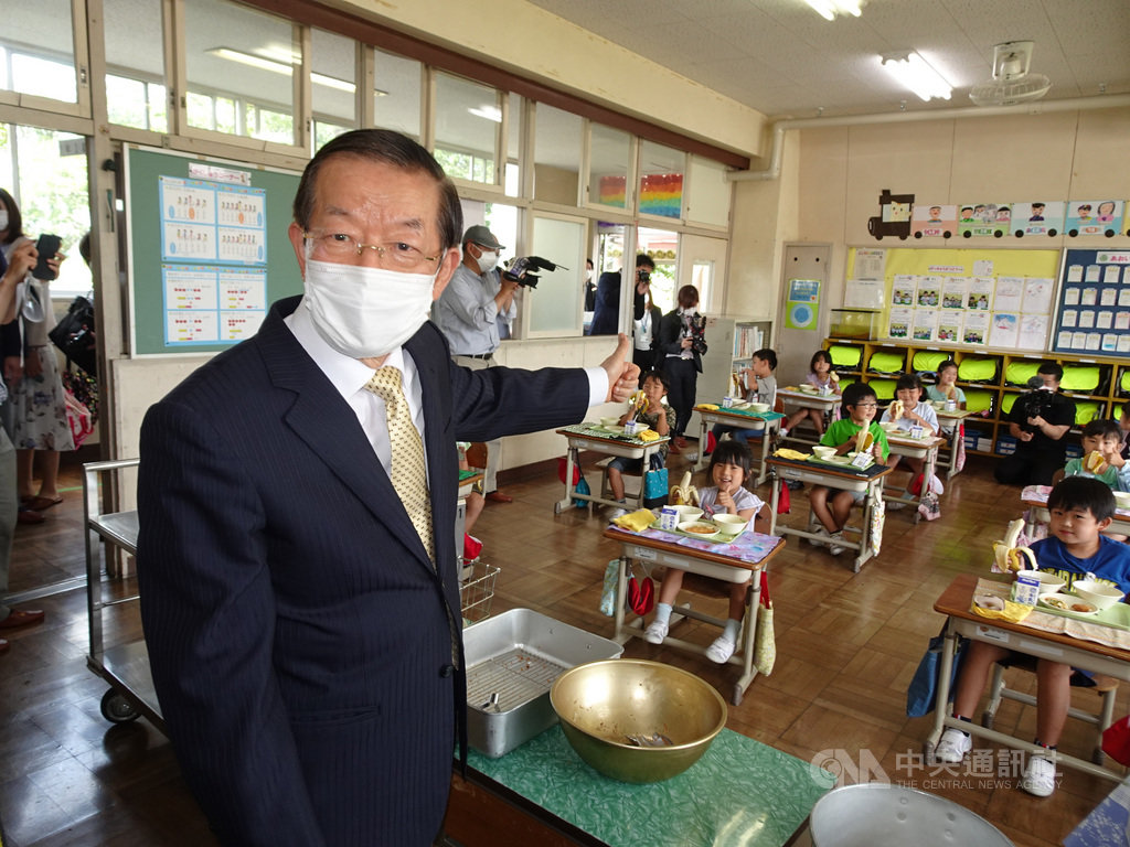 駐日代表謝長廷18日造訪東京奧運台灣隊接待城茨城縣笠間市，贈香蕉給當地學童，看到學童吃得津津有味感到很開心。 圖/中央社