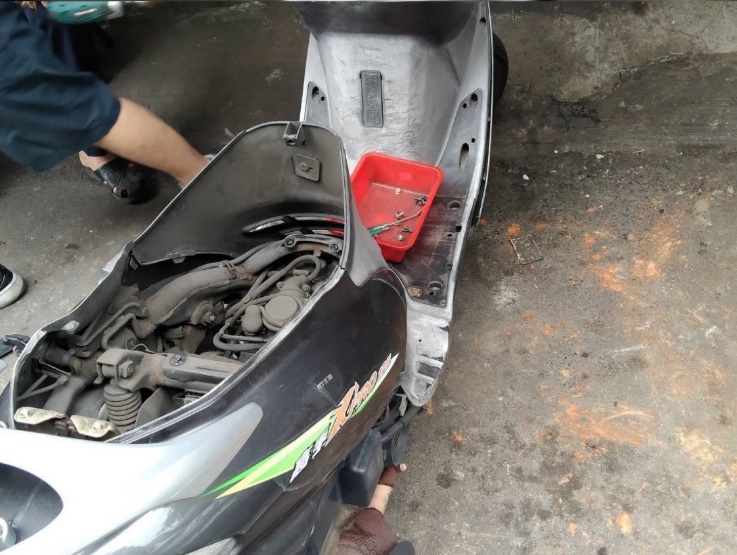 機車行協助拆下車殼，尋找蛇的蹤影。 圖：新北市動保處提供