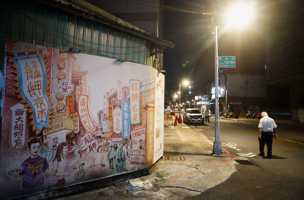 位在北市萬華區的廣州街夜市仍未營業，街上空空盪盪與海報上的夜市熱鬧景象成了鮮明的對比。 圖：張良一/攝