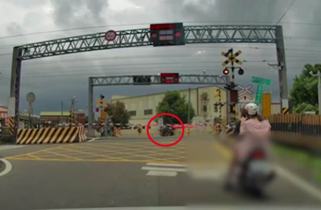一位坐著輪椅的民眾闖入平交道，當時平交道柵欄已經降下，情況相當驚險。 圖：翻攝記者爆料網