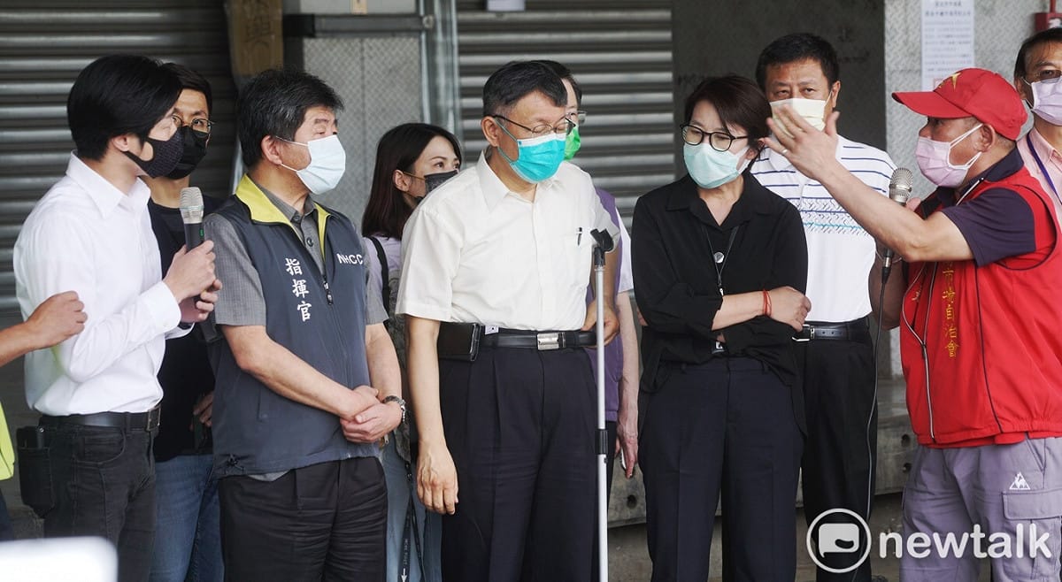 環南市場自治會會長林勝東（紅衣者）嗆聲立委林昶佐「從疫情發生至今，有幫艋舺人民發聲過？」 圖：張良一 / 攝
