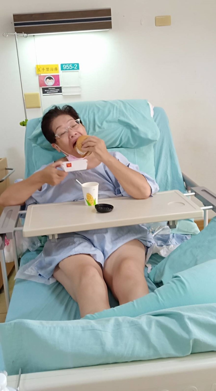 新北重症婦拔管後大口吃漢堡，非常滿足。 光田綜合醫院/提供