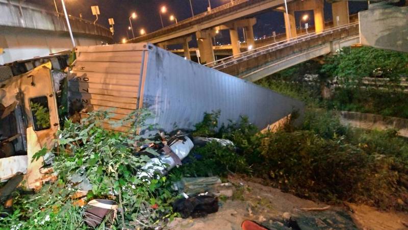 台64快速道路新北市五股路段12日晚間發生車輛墜落事故，一輛貨櫃聯結車從高架道路墜落到地面，駕駛重傷，當場沒有生命跡象，送醫急救。 圖：中央社提供