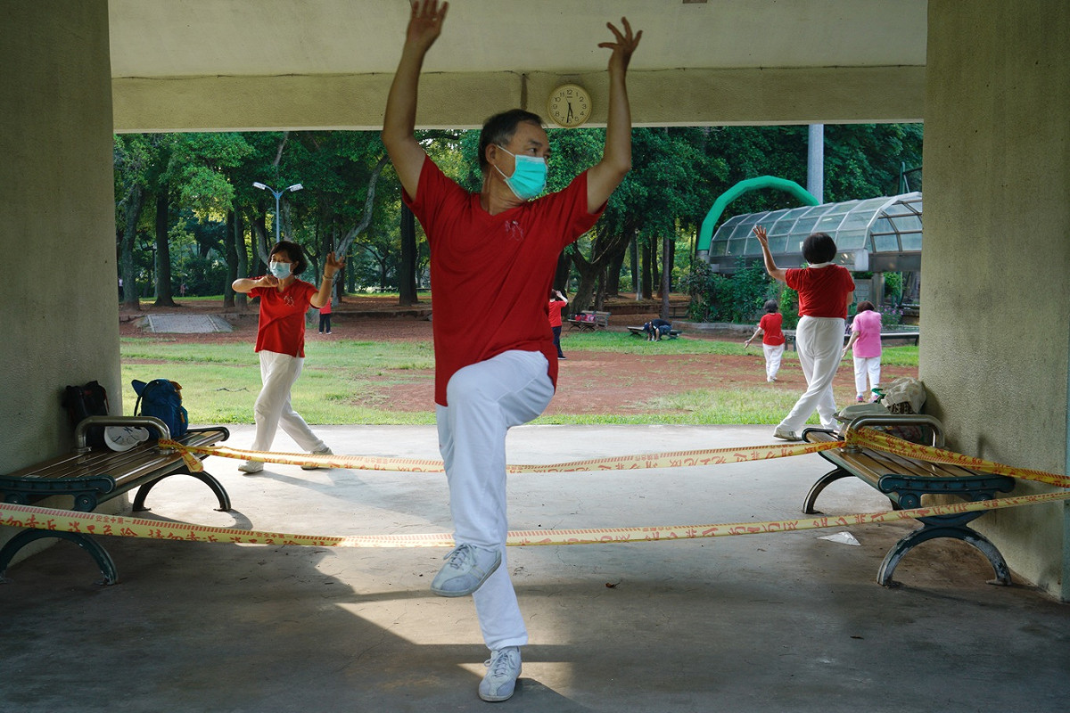 一些民眾清晨在萬華青年公園內運動，雖然今天是微解封首日，但公園內凡事會有身體接觸的體健設施，仍用黃色警戒線圍住。 圖：張良一/攝
