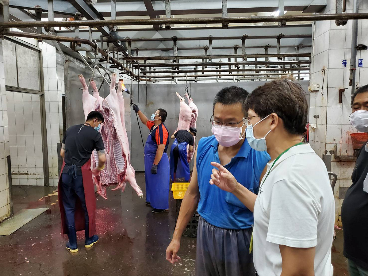 高市農業局副局長王正一(右)稽查鳳山肉品市場夜間屠宰線。 圖：高雄市農業局提供