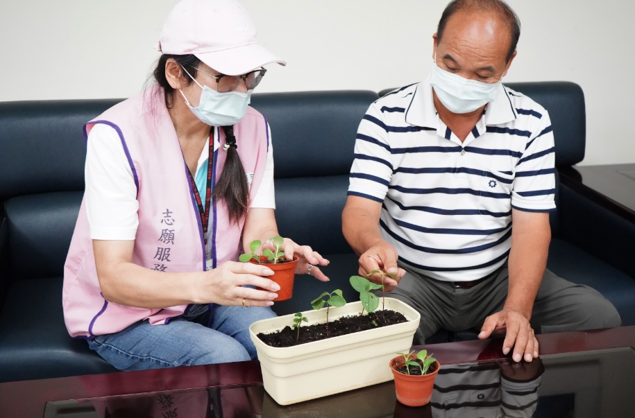 麗園里長(黃添福右)與社福志工討論適合的植栽種植 圖：林口區公所提供