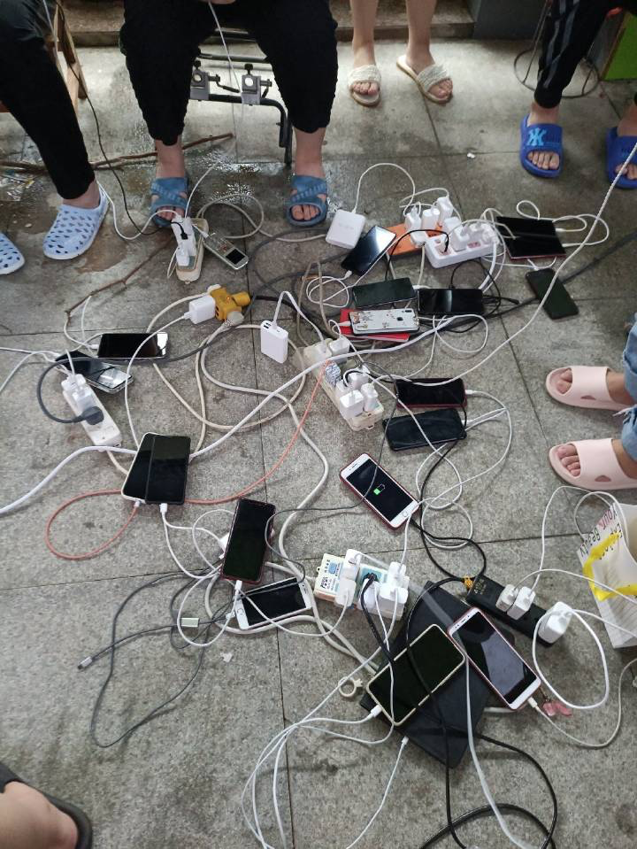 鄭州淹大水，好心的電器行老闆免費為民眾手機充電，方便對外聯繫。 圖 : 翻攝自騰訊網