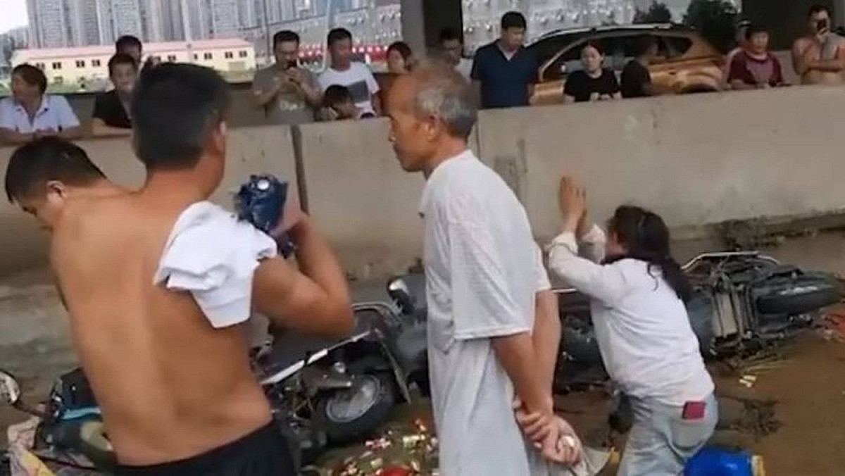 煙酒店的倉庫受暴雨波及，路人爭相搶酒，老闆娘下跪哭求：「不要再搶了，求求你們了」。 圖：翻攝騰訊新聞