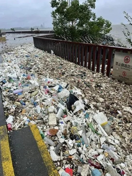 江中大量垃圾被沖上堤岸，親水平台的江堤一夜變成了垃圾堆積場。 圖：翻攝自騰訊網