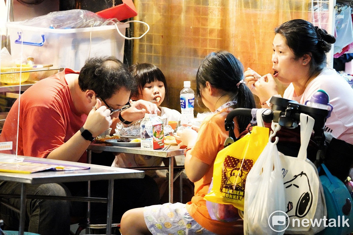 一家子一起享用夜市美食。 圖：張良一/攝