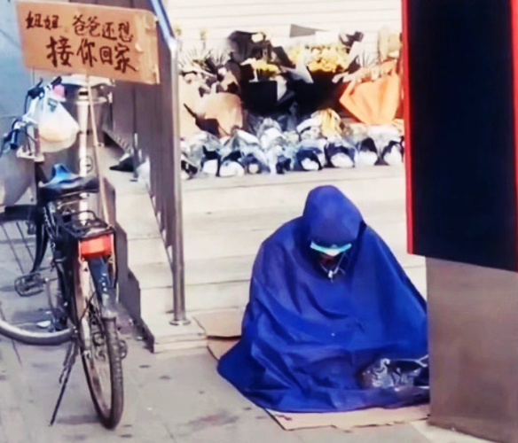 一位父親坐在地鐵出入口，一旁單車上的看牌寫著：「妞妞，爸爸還想接妳回家。」 圖：翻攝微博