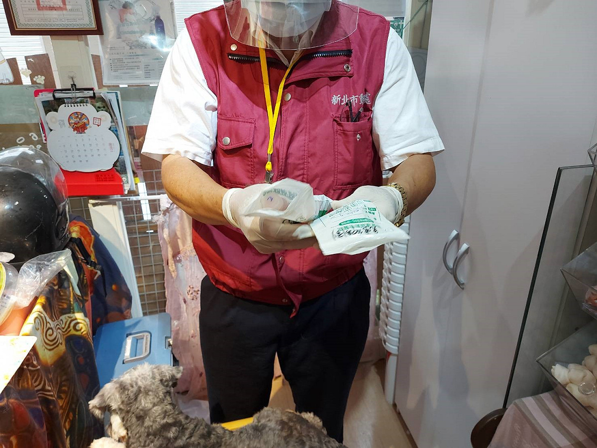 獸醫彭明發檢視ECHO的藥袋，了解病史狀況。 圖、新北市動保處提供