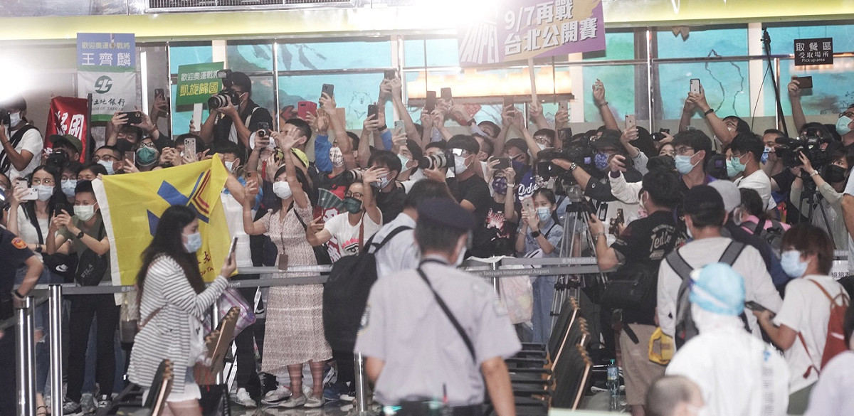 東京奧運羽球代表隊載譽返國，大批球迷機場接機，歡迎男雙金牌得主「麟洋配」。 圖：張良一攝