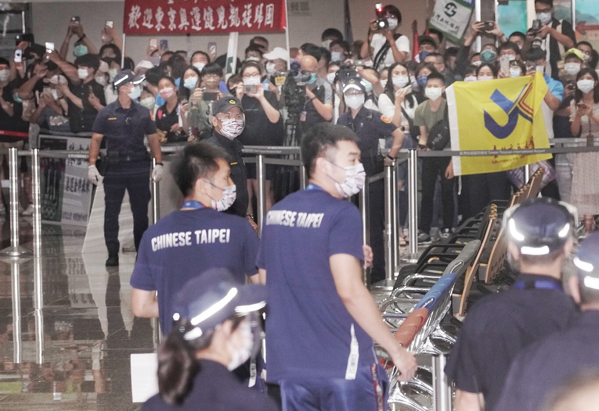 東京奧運羽球代表隊載譽返國，大批球迷機場接機，歡迎男雙金牌得主「麟洋配」。 圖：張良一攝