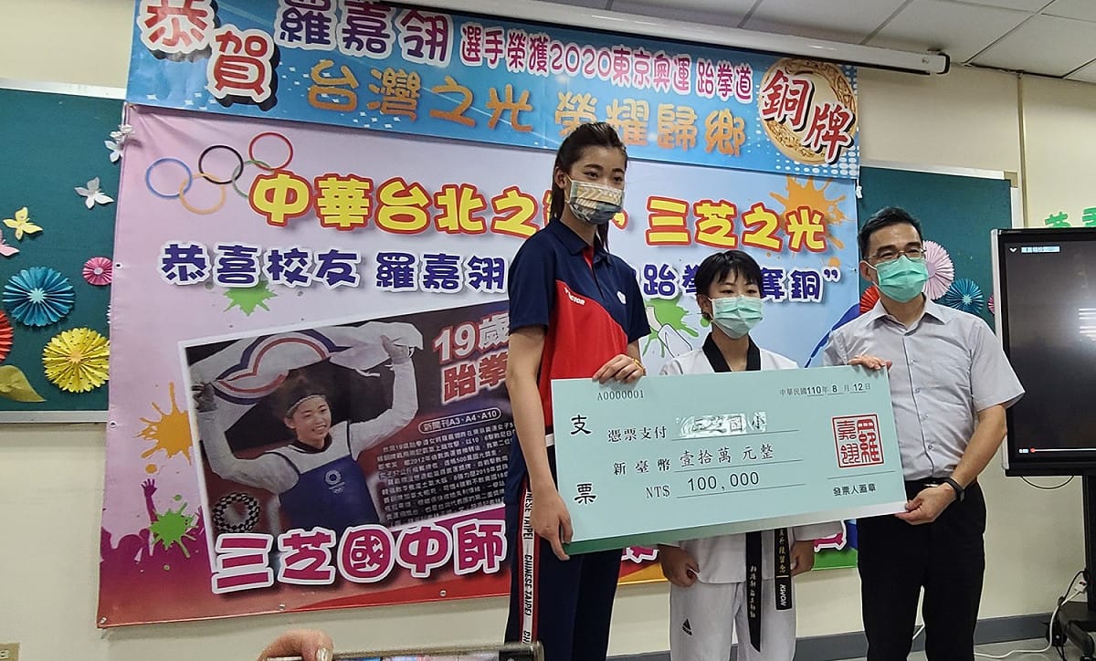 羅嘉翎(左)致贈培訓金予母校三芝國小，由校長李烟長(右)代表接受。 圖：新北市教育局提供