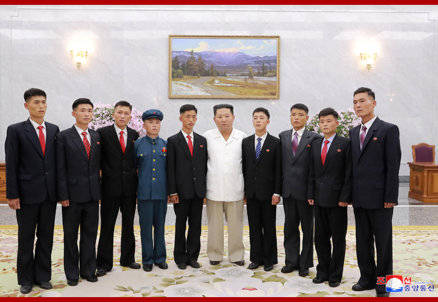 金正恩與「志願」青年合影。 圖 : 翻攝自朝中社
