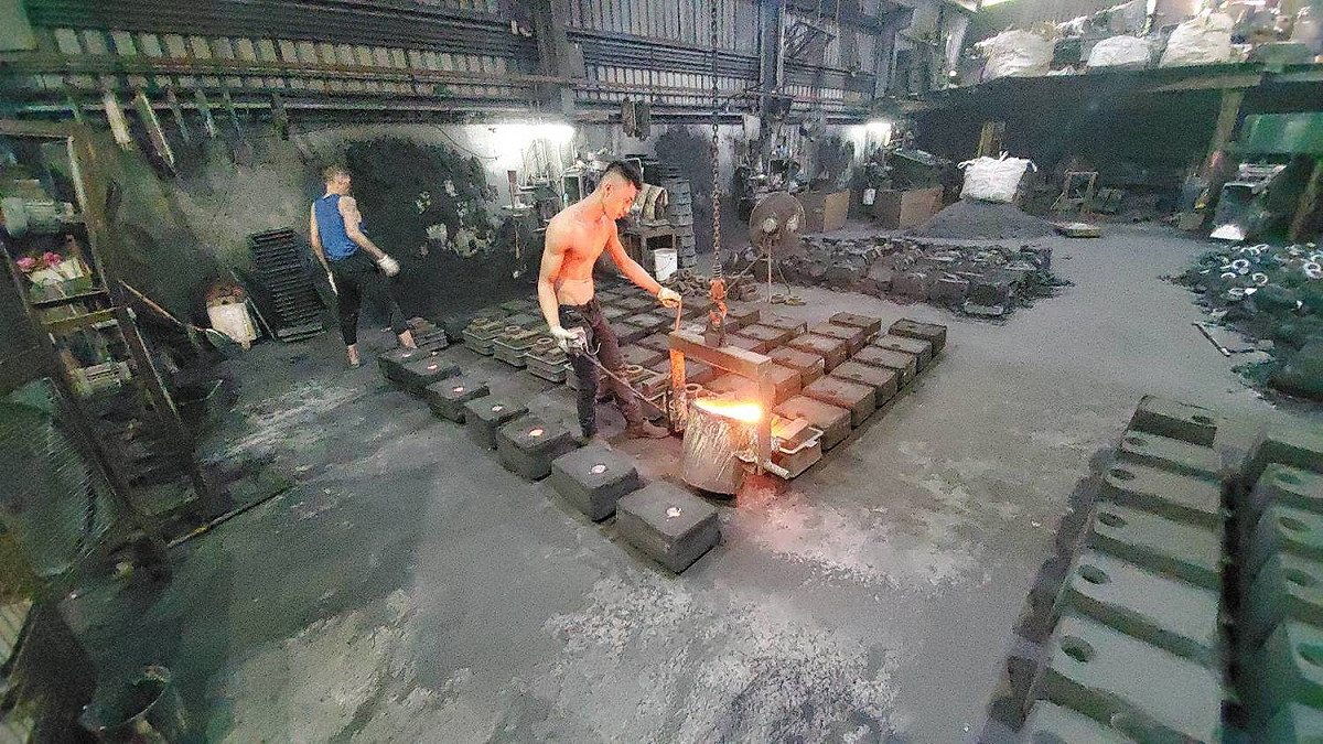 非法鑄造工廠工作人員進行模具灌注作業。 圖：新北市環保局提供
