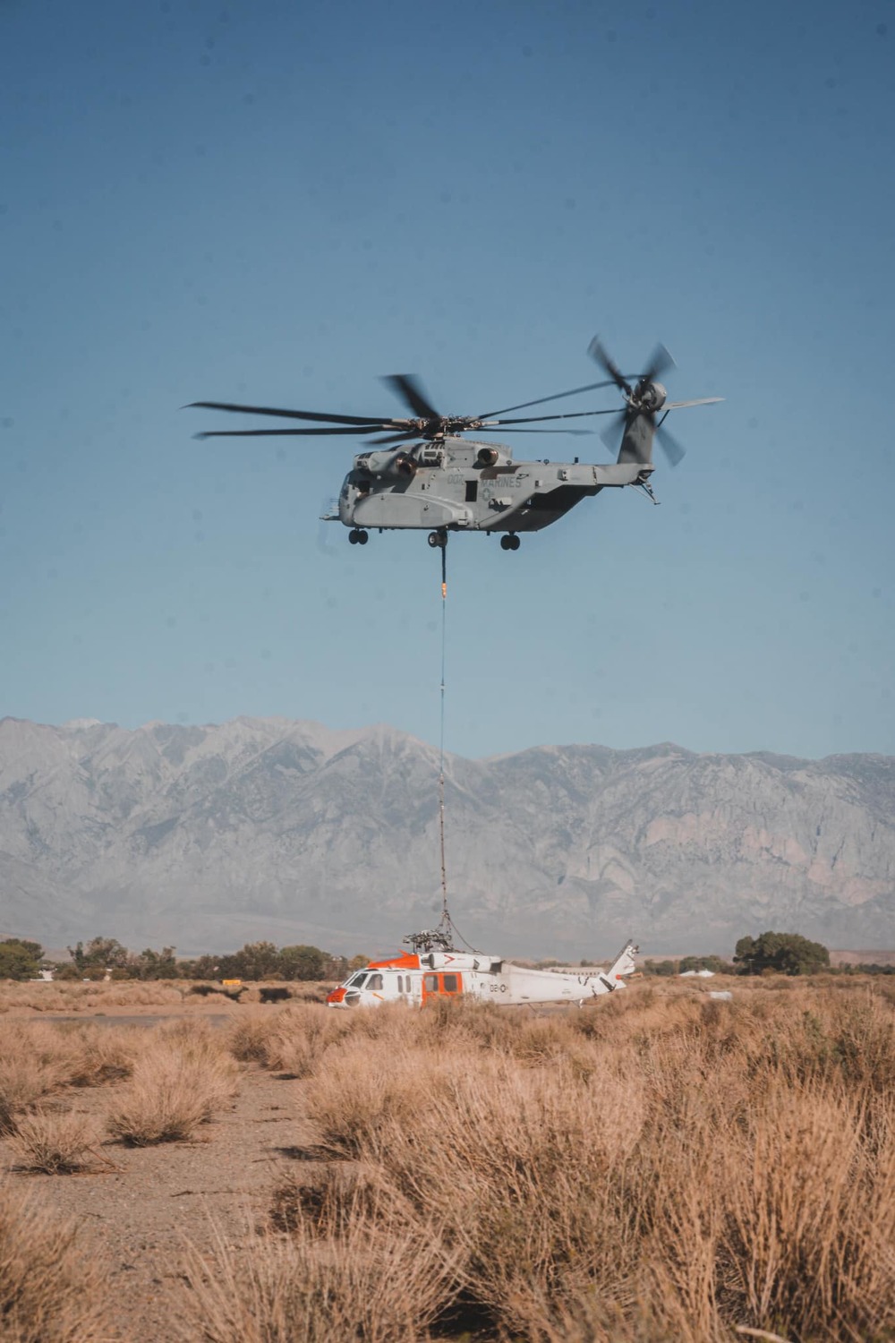 美國海軍陸戰隊「CH-53K種馬王」直升機，受命吊掛7月19日在加州華特山附近迫降的海軍「MH-60S」搜救直升機，形成罕見的直升機吊掛直升機的畫面。 圖：翻攝USMC官網