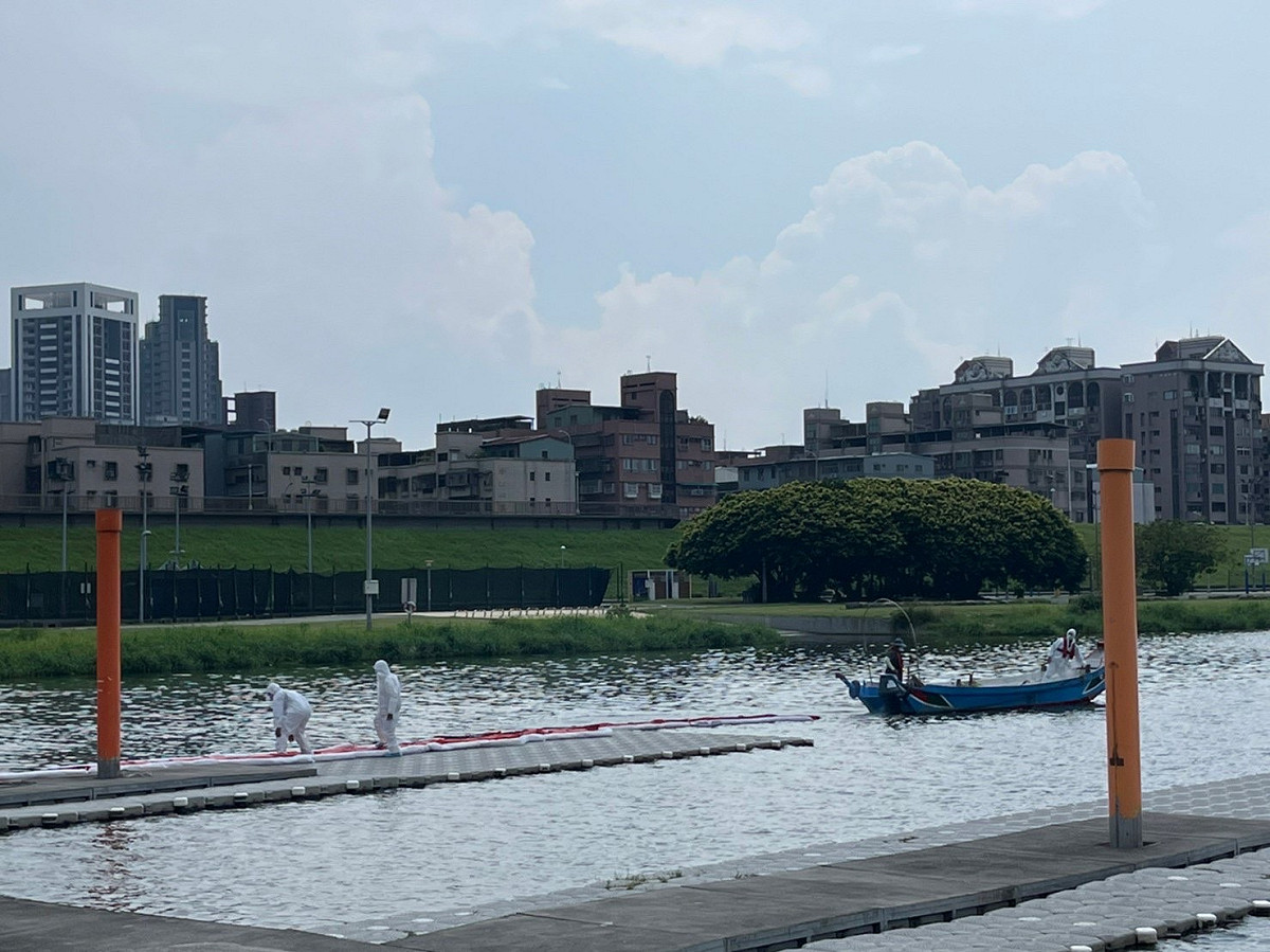 應變小組佈設河川型攔油索將油污圍堵。 圖：新北市環保局提供